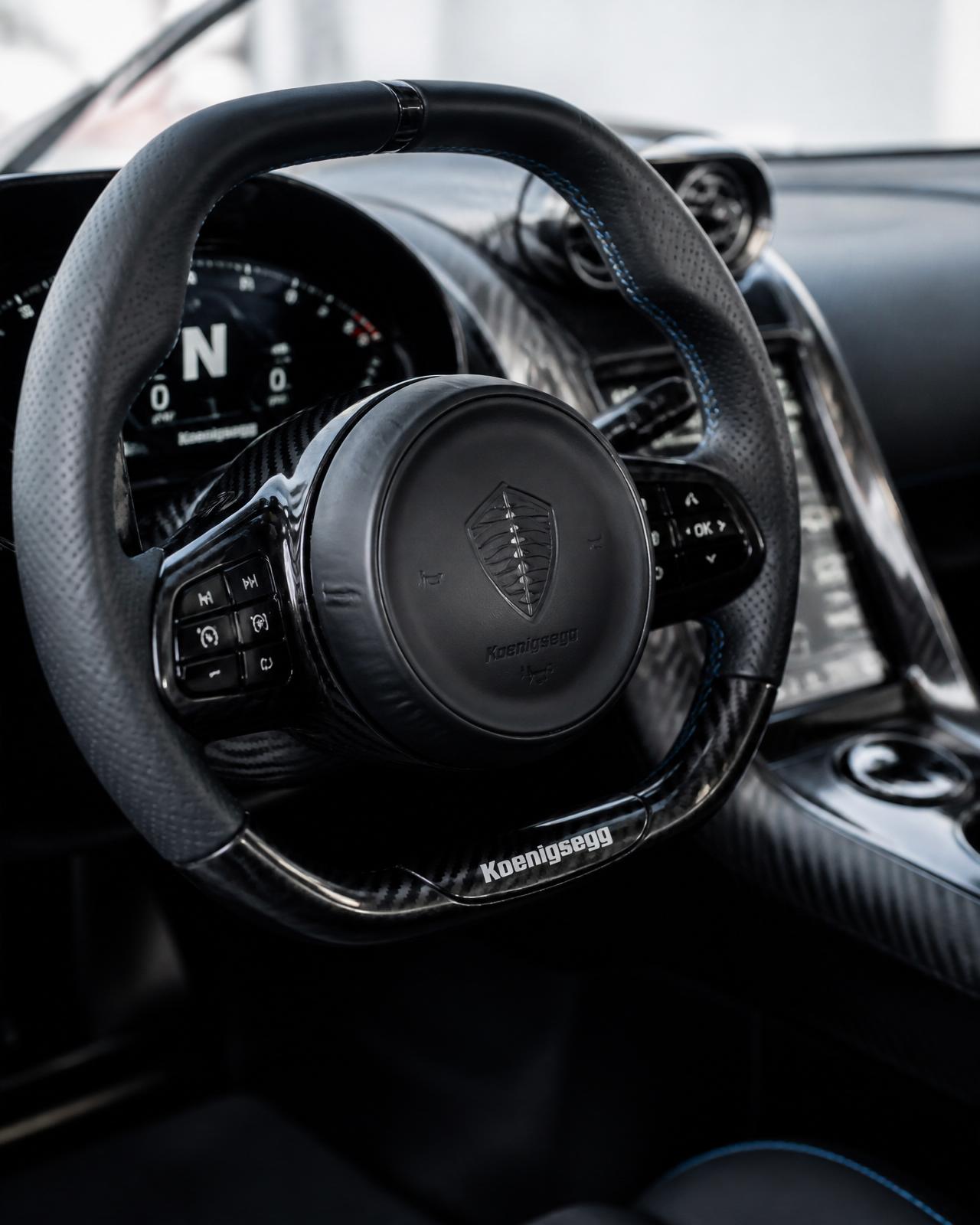Detail of a supercar steering wheel and stitched leather dashboard